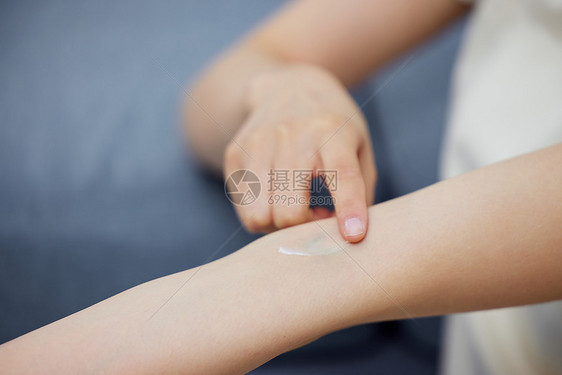 女性往手臂上涂抹膏药特写图片