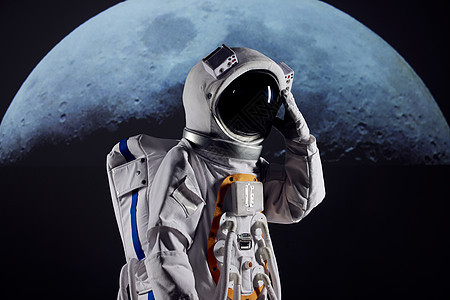 宇航员站在月球前手扶宇航头盔图片