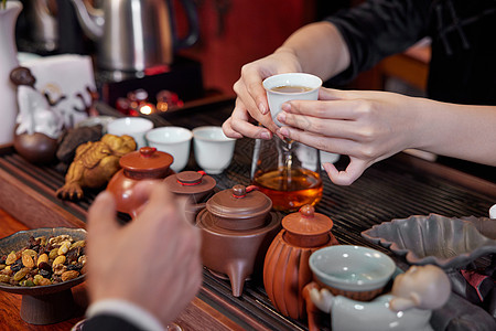 商务会所茶艺师端茶特写背景图片