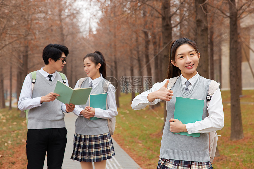 学生学拿书本讨论课题点赞形象图片