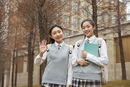 校园美女学生抱着书本打招呼图片