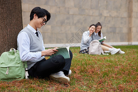 坐在校园草地上学习的青年学生图片