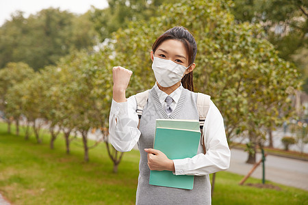 戴口罩的美女大学生抱着书本图片