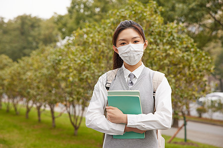 戴口罩的美女学生抱着书本图片