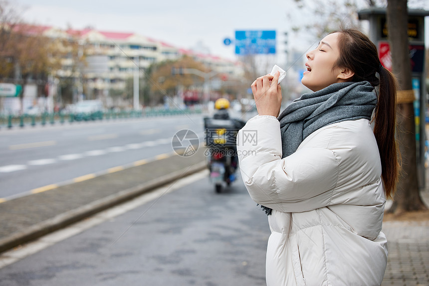 在室外打喷嚏难受的女性图片