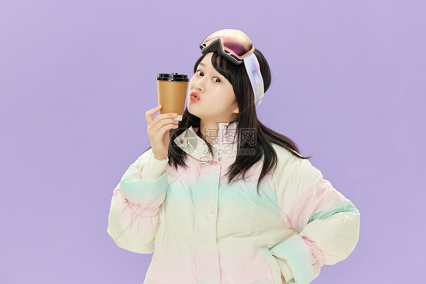 戴着滑雪眼镜手握咖啡杯的女孩图片