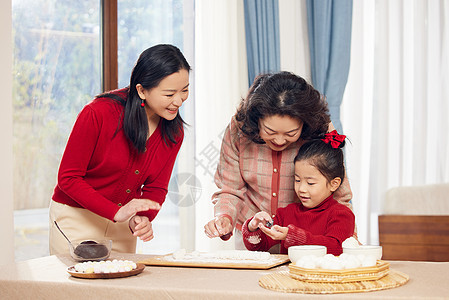 奶奶和妈妈指导小女孩包汤圆图片