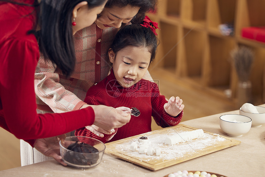 奶奶和妈妈教小女孩包汤圆图片