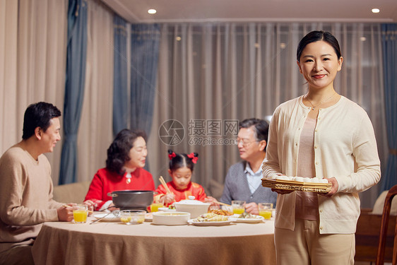 年轻妈妈元宵节聚餐端着汤圆形象图片