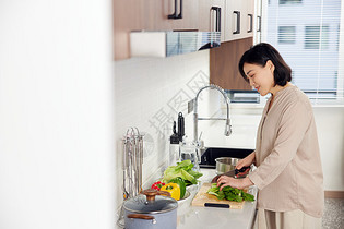 气质中年女性在家厨房切菜图片