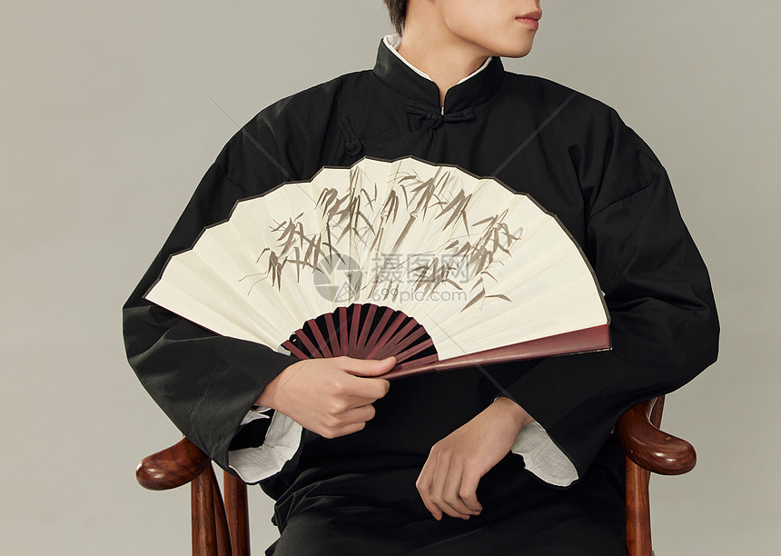 穿着古装手拿扇子的男青年