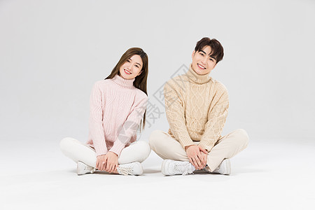韩系情侣坐在地上开心微笑图片