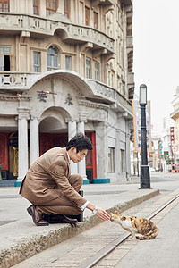 猫空间素材老旧街上穿西装的男性蹲下抚摸猫背景