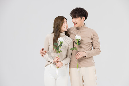 韩系情侣亲密陪伴手拿玫瑰鲜花背景图片
