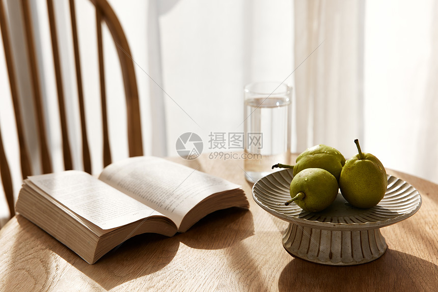木桌上的书籍与水果图片