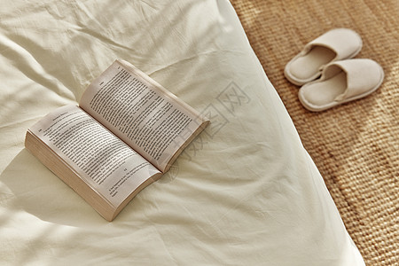 阳光下卧室里的书与拖鞋背景图片
