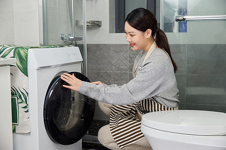 居家女性洗手间使用洗衣机图片