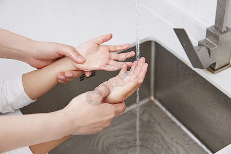 全球洗手日妈妈在教小孩洗手特写背景