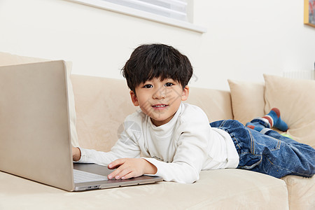 小朋友在沙发上玩耍看电脑图片