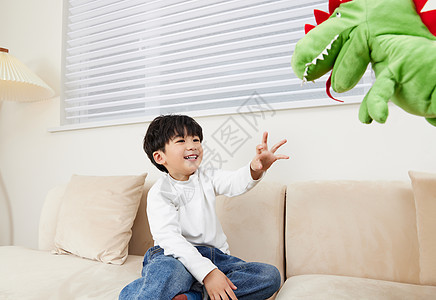 小朋友在沙发上跟玩偶玩耍图片