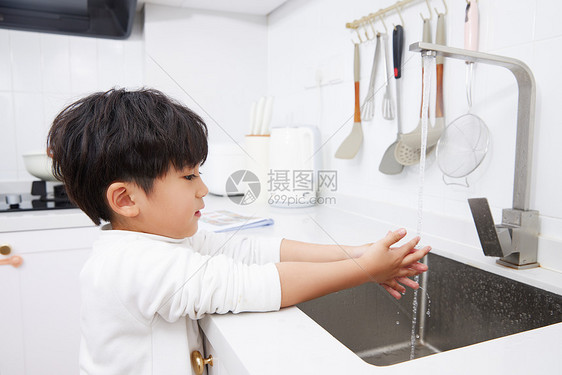 在厨房水池洗手的小男孩图片