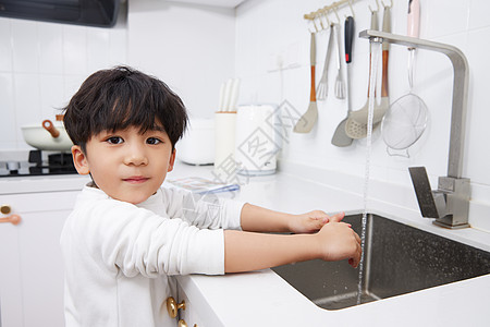 在厨房水池洗手的居家儿童图片