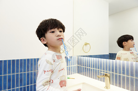 在洗漱台搞怪刷牙的小男孩图片
