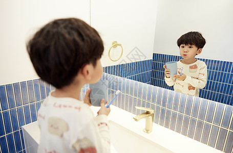 给牙齿洗澡在洗漱台刷牙的小男孩背景