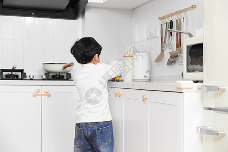 灶台使用厨房用具的居家儿童图片