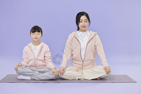 少儿辅导班母女坐在瑜伽垫上冥想背景