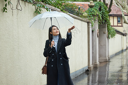 在雨中行走的女性用手接雨水图片