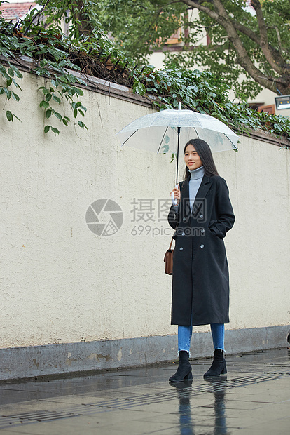 下雨天撑伞行走的女性图片