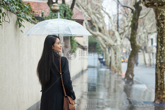 下雨天撑伞走在路边的女性图片