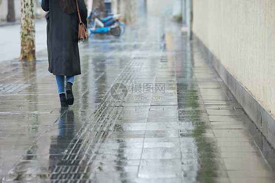 下雨天行走的女性背影特写图片