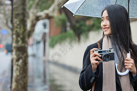 年轻女性雨天拍照图片
