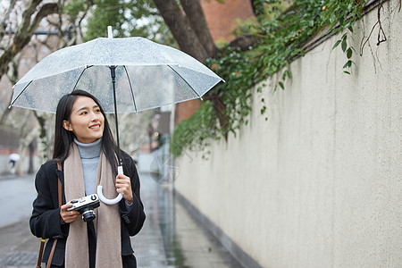 女性雨天逛街拍照高清图片