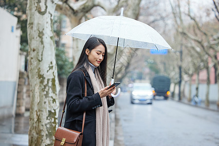 雨天撑着伞在路边等待的女性图片