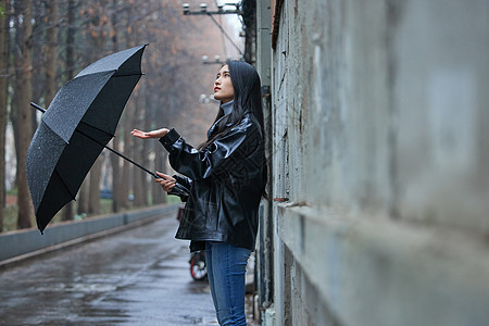 屋檐下躲雨的女性图片