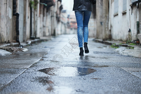 雨天行走的女性腿部特写图片