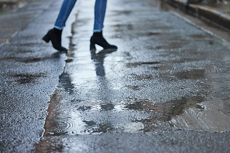 雨天行走的女性腿部特写图片