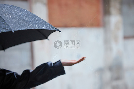 下雨天撑伞的女性手部特写图片