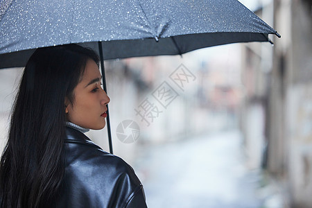 撑着伞表情难过的女性图片