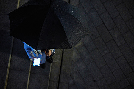 撑着伞使用手机的人俯视视角图片