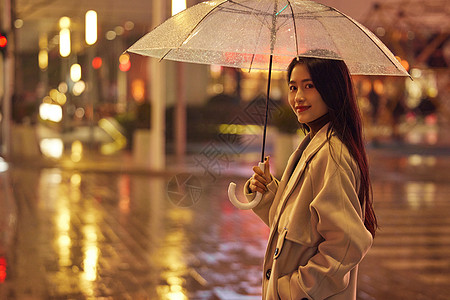 下雨天夜晚城市里散步的女性图片