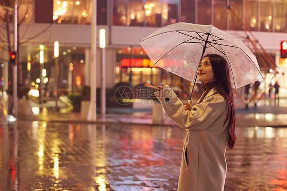 下雨夜晚撑伞走路的女性图片