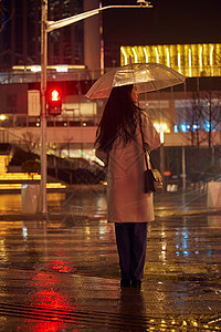 下雨天撑伞等红绿灯的女性背影图片