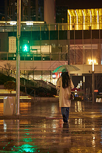 下雨天过马路的女性背影图片