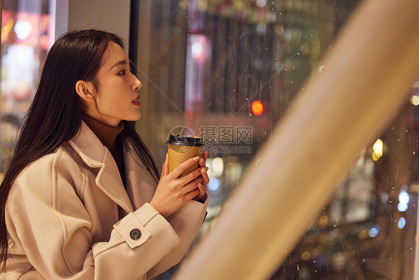 雨天坐在咖啡厅看向窗外的女性图片