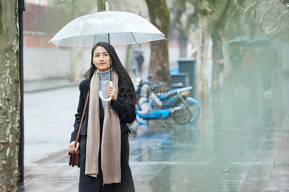 下雨天在城市里行走的女性图片