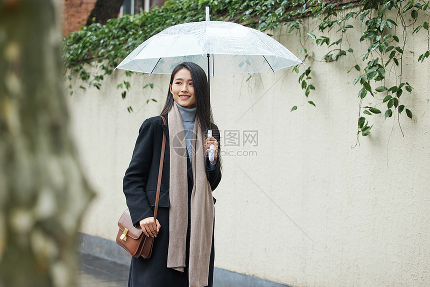 下雨天在城市里行走的女性图片